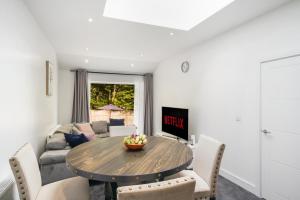 a dining room with a table and a couch at Near Wembley Ground Floor Flat with Garden & Parking in The Hyde