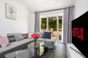 a living room with a couch and a glass table at Near Wembley Ground Floor Flat with Garden & Parking in The Hyde