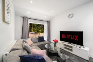 a living room with a couch and a television at Near Wembley Ground Floor Flat with Garden & Parking in The Hyde