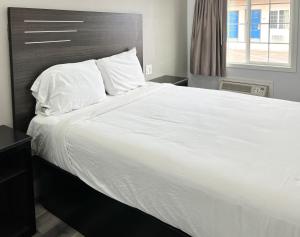 a large bed with white sheets and pillows at Motel 6 Santa Cruz, CA in San Jose +2 photos