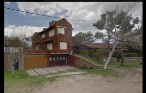 a brick house with a garage in front of it at Apartamento Calamar II in Valeria del Mar