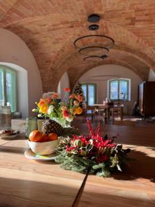 einen Tisch mit einer Schale Obst und Blumen darauf in der Unterkunft Podere Le Marene in Scoppieto + 80 Fotos