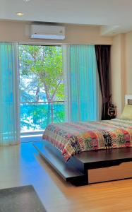 a bedroom with a bed and a large window at Nai Thon Condo Unit in Nai Thon Beach