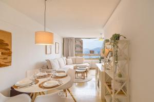 a living room with a white couch and a table at Oasis Levante Beach Benidorm - Trinisol II in Benidorm