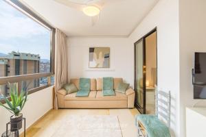 a living room with a couch and a large window at Oasis Levante Beach Benidorm - Trinisol II in Benidorm