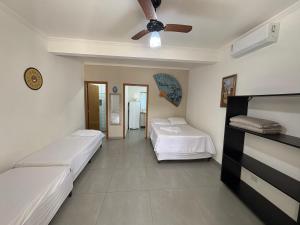 a bedroom with two beds and a ceiling fan at Chalé do Gaúcho in Ubatuba