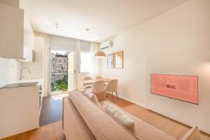 Una sala de estar con un sofá y un televisor en una pared. en GuestReady - Elias Garcia Apartments, en Lisboa