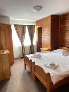 a bedroom with a large bed with two towels on it at Camere de Inchiriat Ceahlau in Ceahlău