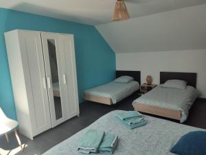 a blue room with two beds and a mirror at La Voilerie in Fécamp