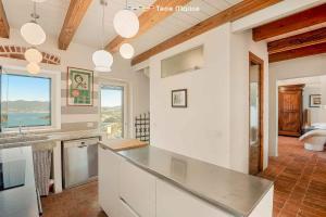 a kitchen with white cabinets and a large window at Luxury Penthouse, Terre Marine in Lerici