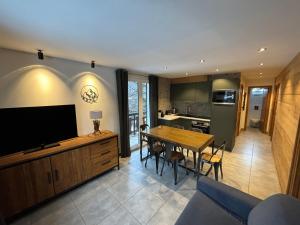 a kitchen and dining room with a table and a television at 3 pièces, 2 chambres, balcon et parking, pour 6 personnes - FR-1-263-89 in Valloire
