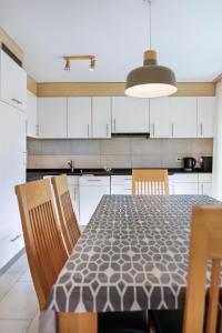 a kitchen with a table and chairs and white cabinets at Haus Snow Fun B in Saas-Fee