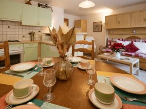 a kitchen with a wooden table with plates and glasses at Appartement 2 pièces cabine pour 6 pers, exposé Sud, à Valloire, animaux admis - FR-1-263-108 in Valloire