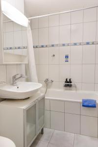 a white bathroom with a sink and a tub at Haus Snow Fun B in Saas-Fee