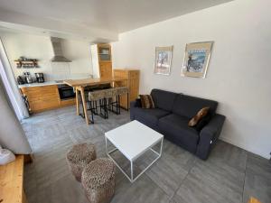 a living room with a couch and a table at Charmant T2 pour 4 pers avec Sauna, WiFi et Parking privé - FR-1-263-88 in Valloire