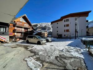 a parking lot with cars parked in front of a building at Charmant T2 pour 4 pers avec Sauna, WiFi et Parking privé - FR-1-263-88 in Valloire