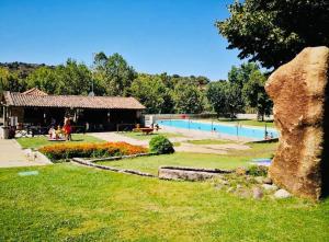 a park with a large rock and a pool at Casa do Regedor in Pinhel