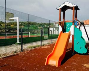 a playground with an orange and green slide at Casa do Regedor in Pinhel