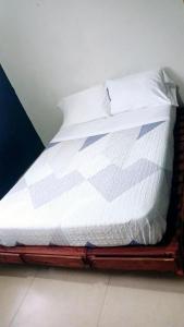 a bed with white sheets and pillows on it at La casa de Issa in Alto Boquete