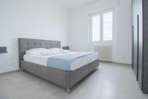 デセンツァーノ・デル・ガルダにあるvicino al lago, Casa Leonardoの白い部屋に大型ベッド1台が備わるベッドルーム1室が備わります。