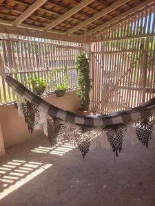 a balcony with potted plants and a hammock at Sossego Meu in Soure