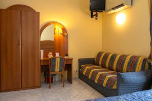 a living room with a couch and a table with a mirror at Albergo Ristorante Roma in Arma di Taggia