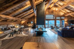 マニグードにあるLodge Les Murailles Luxury Unique Alpin Chalet Manigod La Clusazの木製の天井とテーブルが備わる広いリビングルーム +98枚の写真