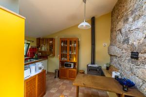 a kitchen with a table and a stone wall at Quinta do Borges in Guarda