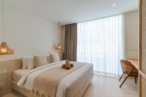 a bedroom with a bed with a teddy bear on it at Villa Valli 8, Luxury Mediterranean Villa Bingin in Uluwatu