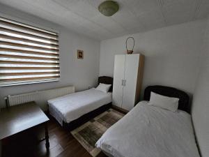a bedroom with two beds and a cabinet and a window at Apartman-Apartment-Stan Ilidža in Sarajevo