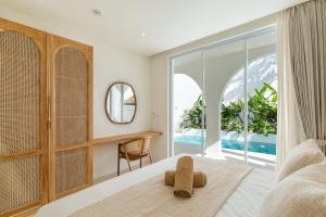 a bedroom with a bed and a desk and a window at Villa Valli 8, Luxury Mediterranean Villa Bingin in Uluwatu