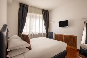 una camera d'albergo con un letto e una televisione di Casa Sacchi by Hili a Roma