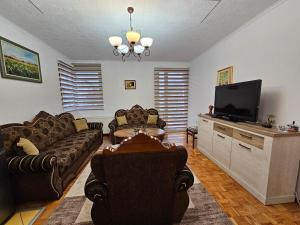 a living room with couches and a flat screen tv at Apartman-Apartment-Stan Ilidža in Sarajevo +7 photos