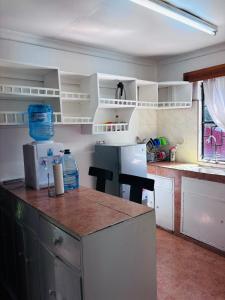 a kitchen with white cabinets and a counter top at Hidden Gem 32 acre road in Nairobi +8 photos