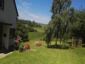 a yard with a tree and flowers next to a house at Forest Haven in Filz in Filz +32 photos