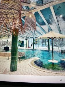 a large swimming pool with an umbrella in a building at Lomarinne2A6 in Ikaalinen