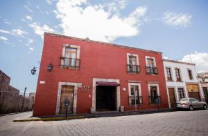 a red building on the side of a street at Pórtico Hotel & Galería in Morelia