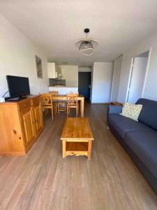 a living room with a couch and a table at Appartement T2 vue sur Pyrénées in Germ +7 photos