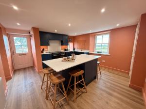 a kitchen with a island with stools in it at Peace Cottage in Darlington