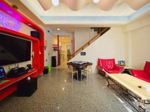 a living room with a red couch and a tv at 小熊城堡民宿-免費停車 !!新歌KTV-過山車電動麻將-露天烤肉-以上設備僅限包棟使用 # 選Villa才是包棟 # - 16人以下可少人包棟請電聯!! in Hualien City
