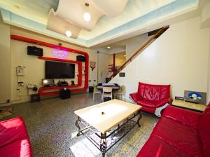 a living room with red furniture and a table at 小熊城堡民宿-免費停車 !!新歌KTV-過山車電動麻將-露天烤肉-以上設備僅限包棟使用 # 選Villa才是包棟 # - 16人以下可少人包棟請電聯!! in Hualien City +3 photos