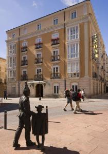 Una statua di un uomo e una donna davanti a un edificio di Hotel Norte y Londres a Burgos