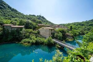a bridge over a river next to a village at Casale del Tempo Lento in Narni