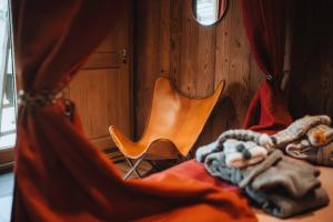 a bed with a orange chair in a room at Chalet SALOON avec SPA privatif in Le Biot