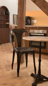 una silla negra sentada junto a una mesa de madera en FoxRoom by #Fox - Studio facing Metz train station, en Metz