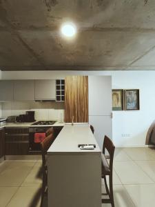 eine Küche mit Tisch und Stühlen in einem Zimmer in der Unterkunft Nuevo y moderno departamento a estrenar en el corazón de Fishertoon in Rosario + 2 Fotos