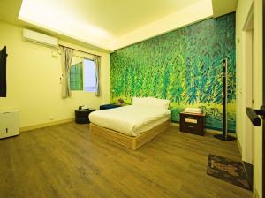a bedroom with a bed and a green wall at 小熊城堡民宿-免費停車 !!新歌KTV-過山車電動麻將-露天烤肉-以上設備僅限包棟使用 # 選Villa才是包棟 # - 16人以下可少人包棟請電聯!! in Hualien City