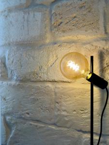 una lampada con una luce di vetro su una parete di Casa delle Zie a Lecce