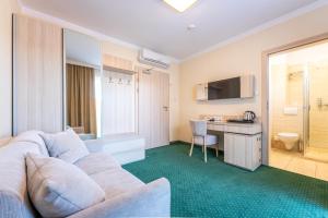 a living room with a white couch and a desk at Villa Cannes Jastarnia in Jastarnia