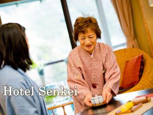 una mujer está de pie en una mesa con un objeto en Senkei, en Hakone